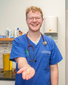 Vet Tom Maxwell holds out the offending radiator cap that Ernie swallowed.